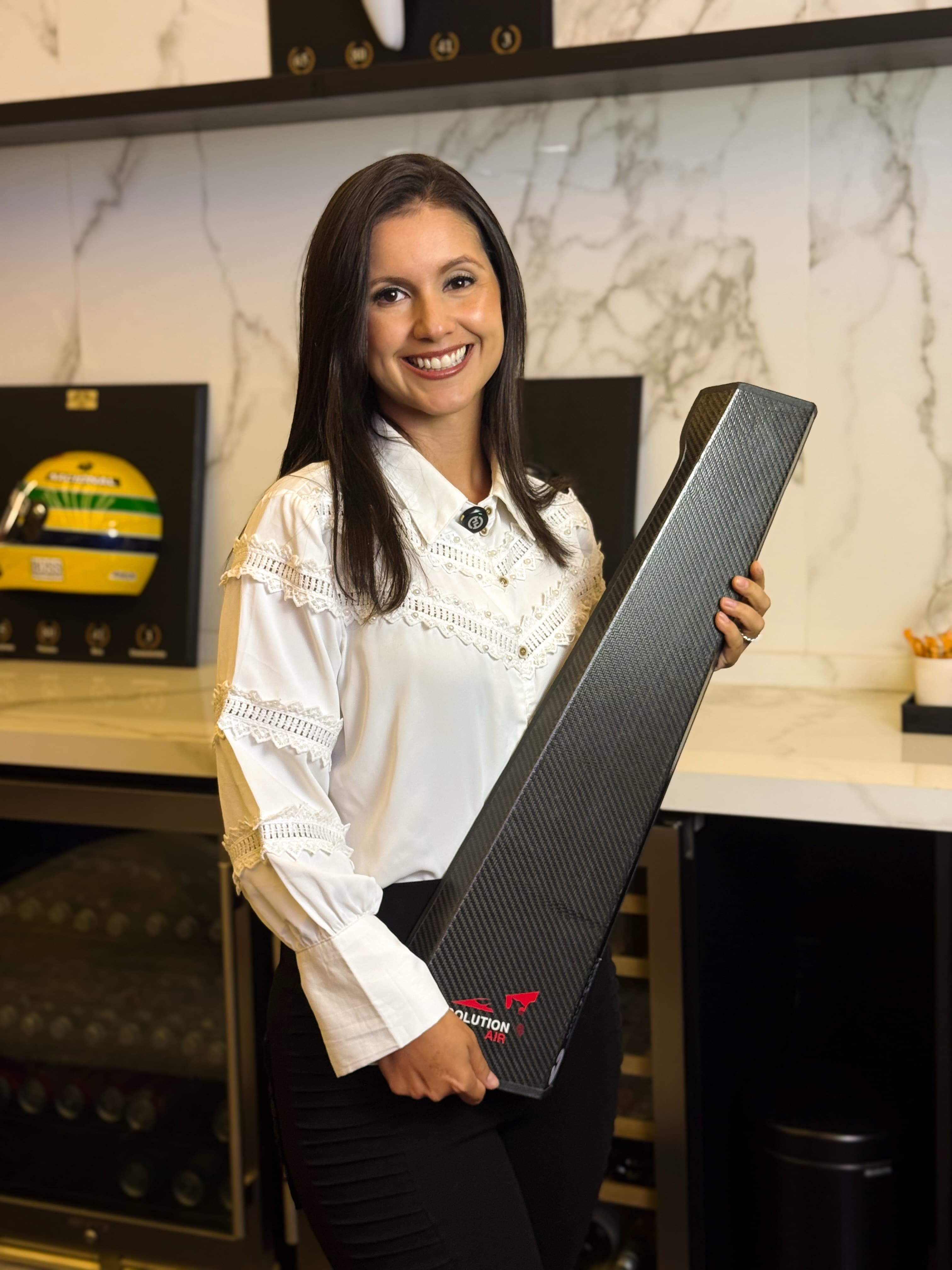 Consultora da Solution Place segurando uma coluna de fibra de carbono com a marca Solution Air