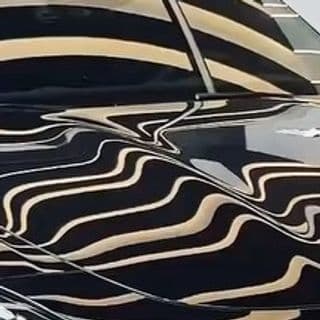 Reflexo da pintura preta de um carro na fábrica